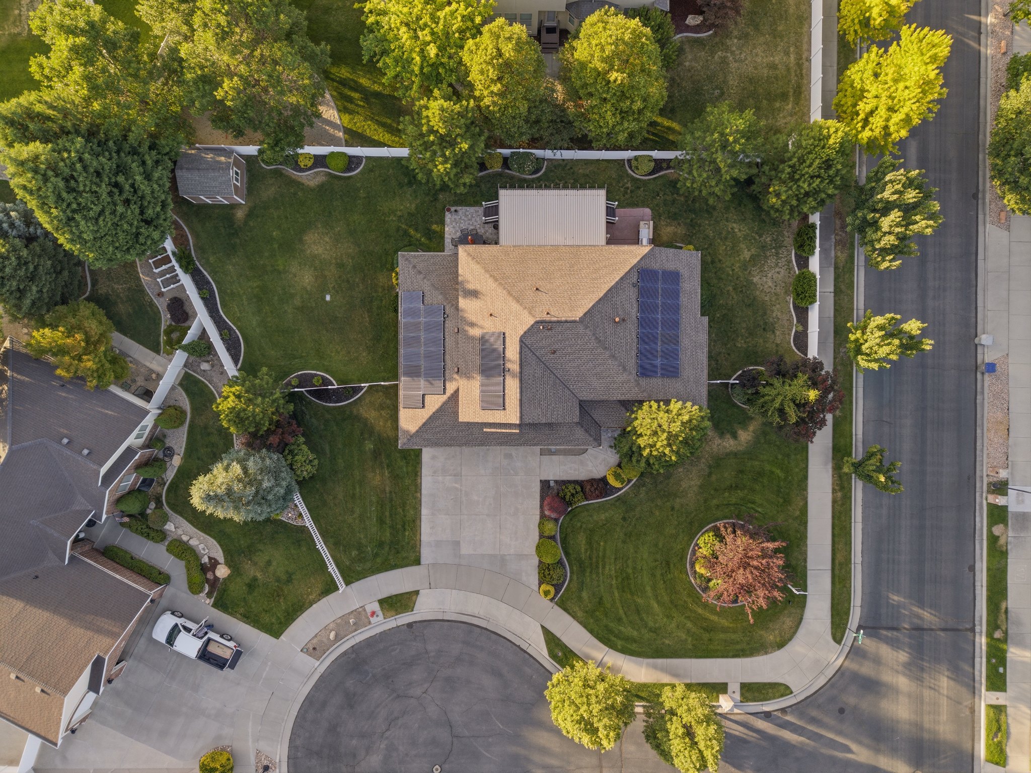 Aerial perspective showcasing a residential property with a shingled roof and solar panels