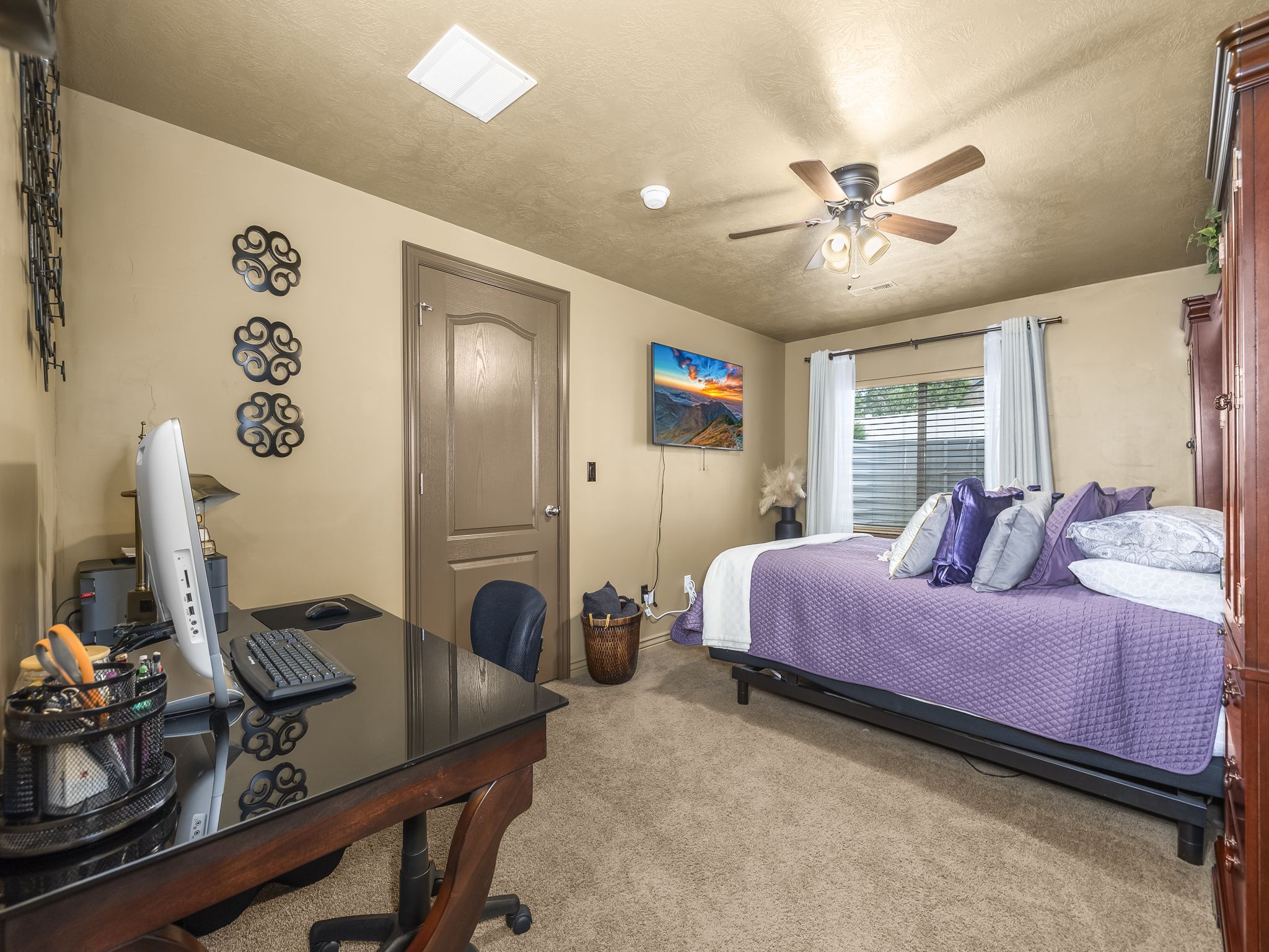 Carpeted room with a ceiling fan light fixture, textured walls, and a window with blinds
