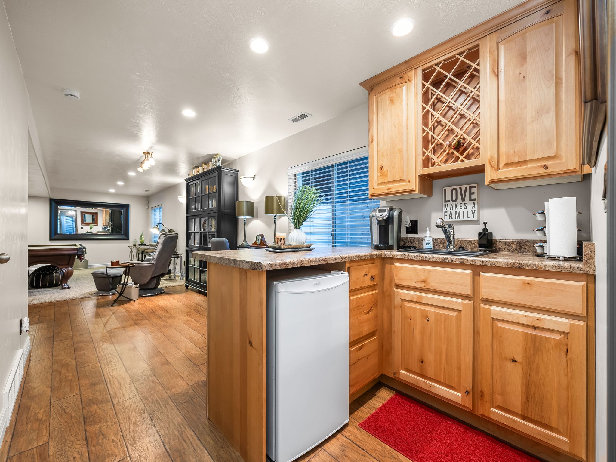 Wet bar featuring wood cabinetry, stone-finish countertops, and an integrated wine rack