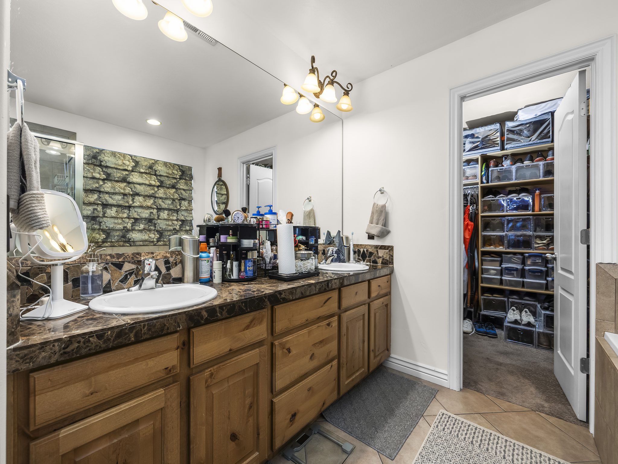 Double vanity featuring two undermount sinks, rich wood cabinetry, and a stone-finish countertop