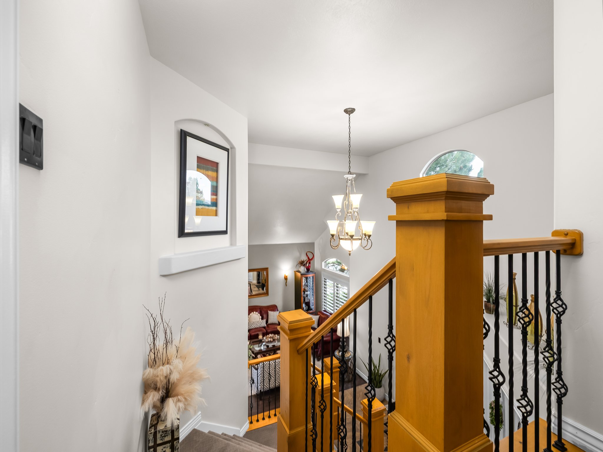 Staircase with wood-finish handrails and black wrought iron balusters