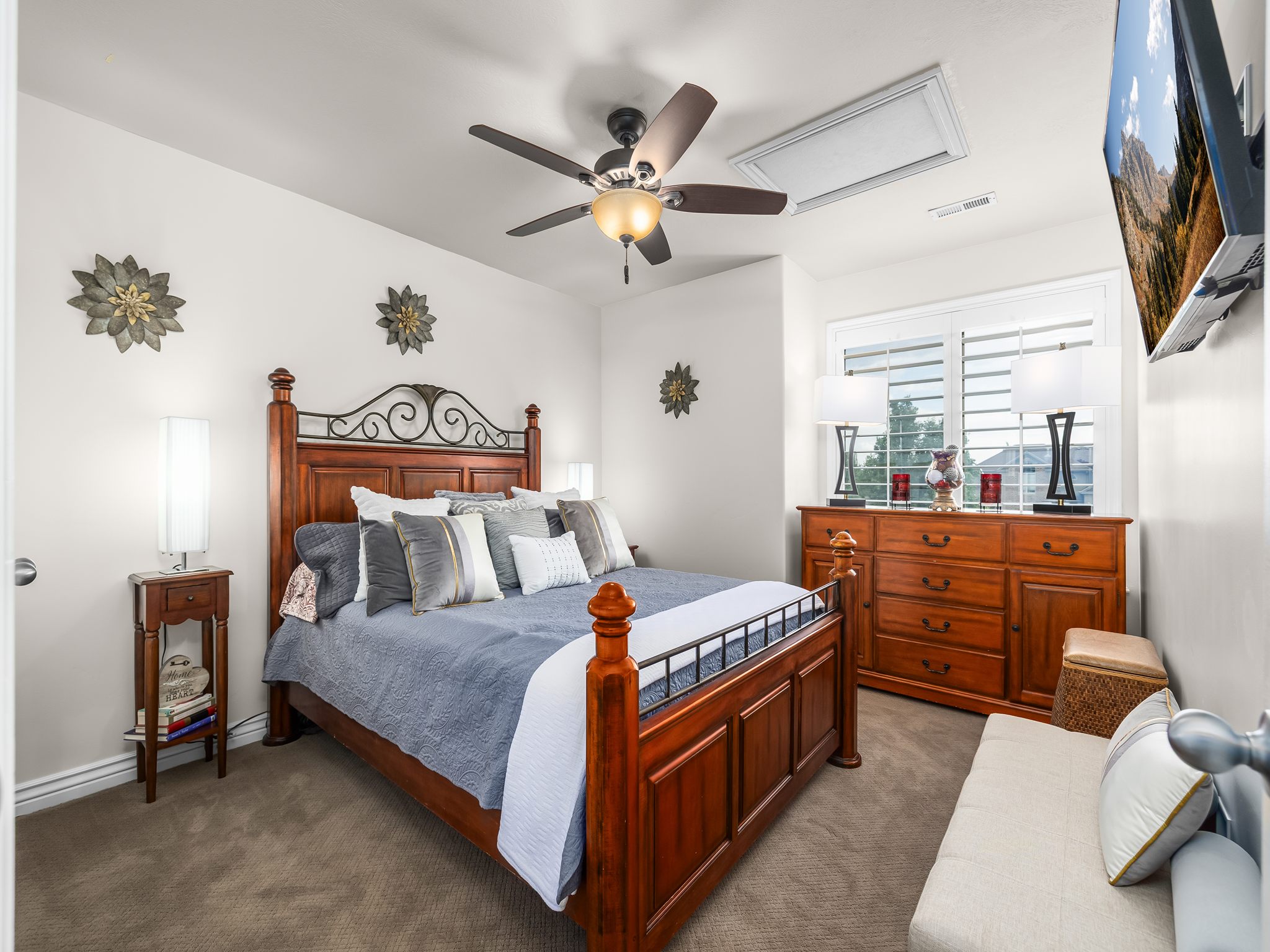 Carpeted room featuring a ceiling fan with integrated lighting, a window with white blinds, and a wall-mounted television
