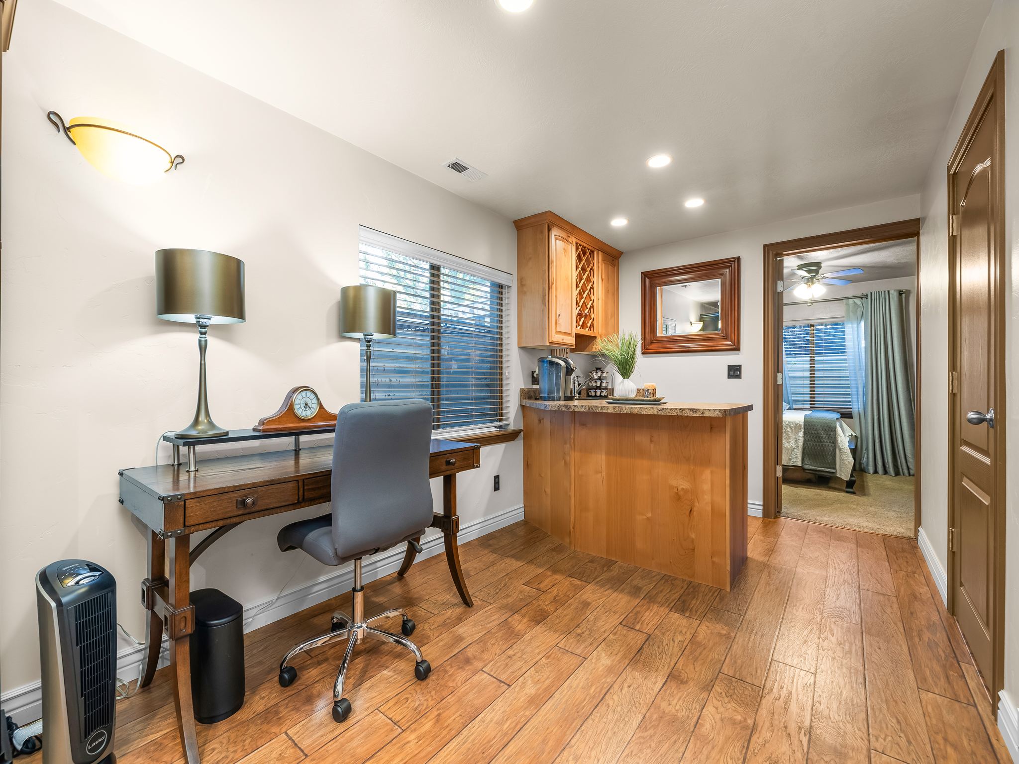 Wood-finish flooring throughout, featuring a built-in wet bar with wood cabinetry and a stone-finish countertop