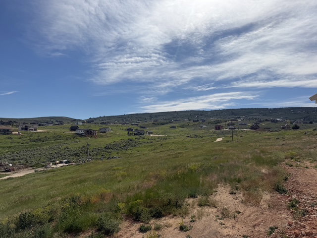 Expansive undeveloped land featuring rolling hills and distant properties