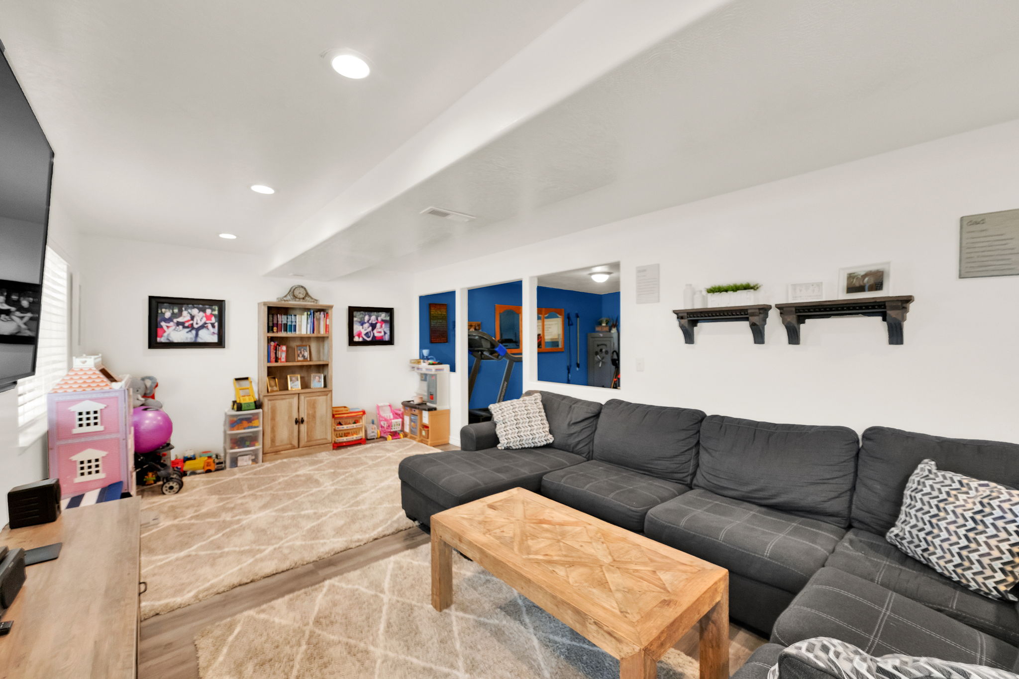 Spacious room featuring wood-finish flooring, recessed lighting, and a neutral color palette