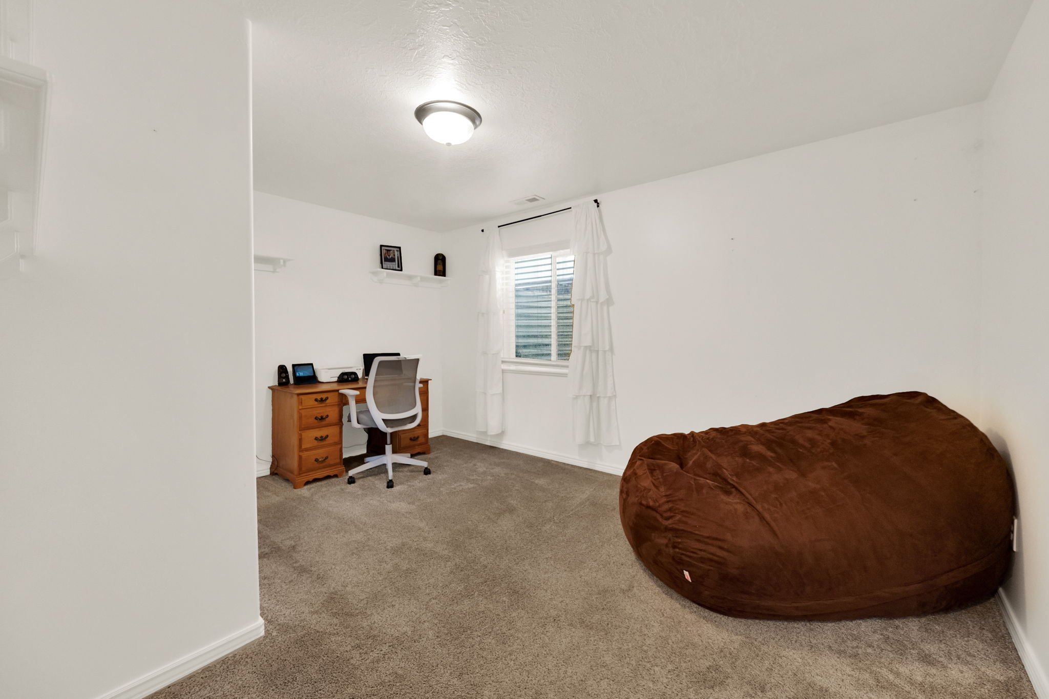 Versatile interior room featuring neutral carpeting and white wall finishes