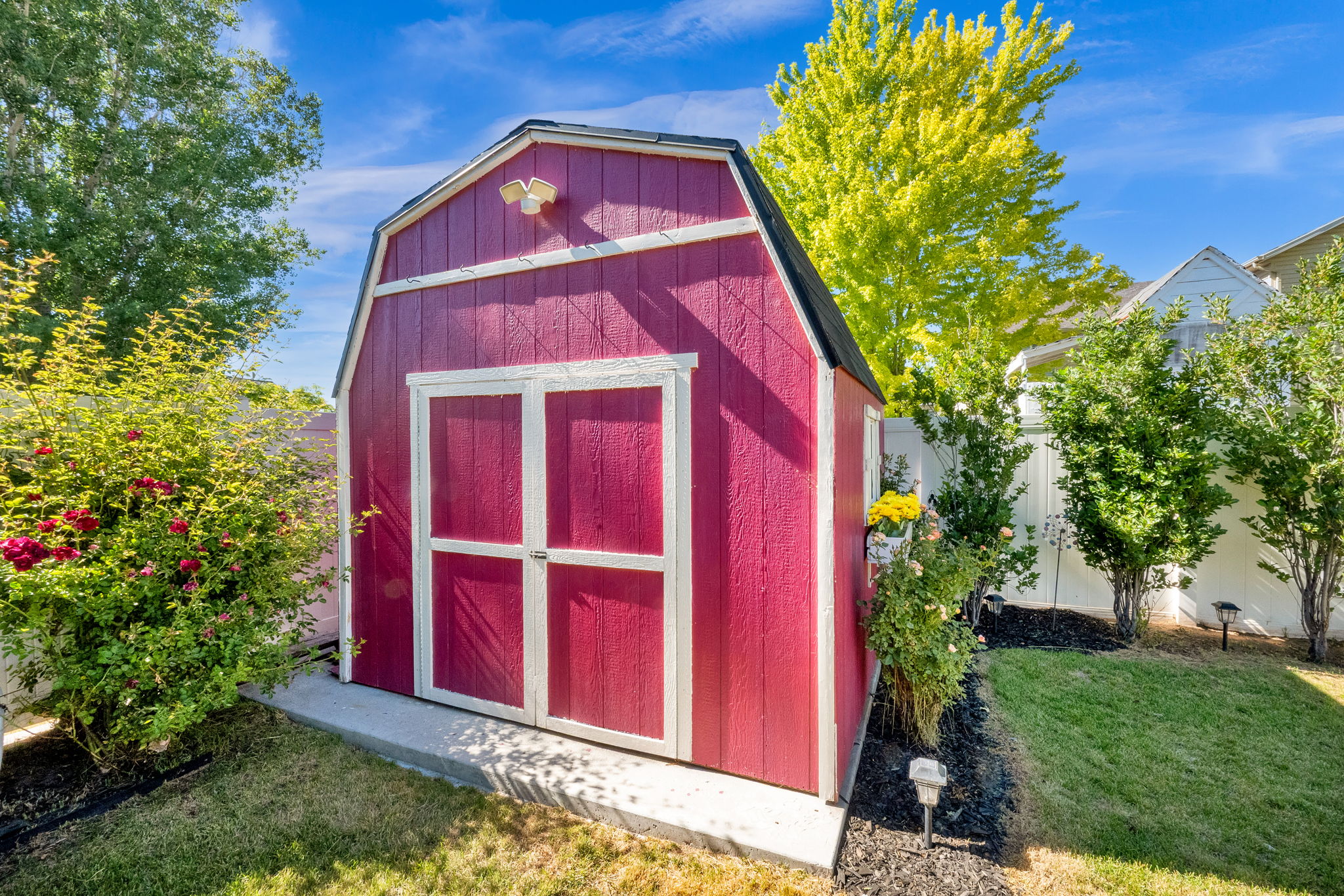 Red barn-style shed with white trim and double doors