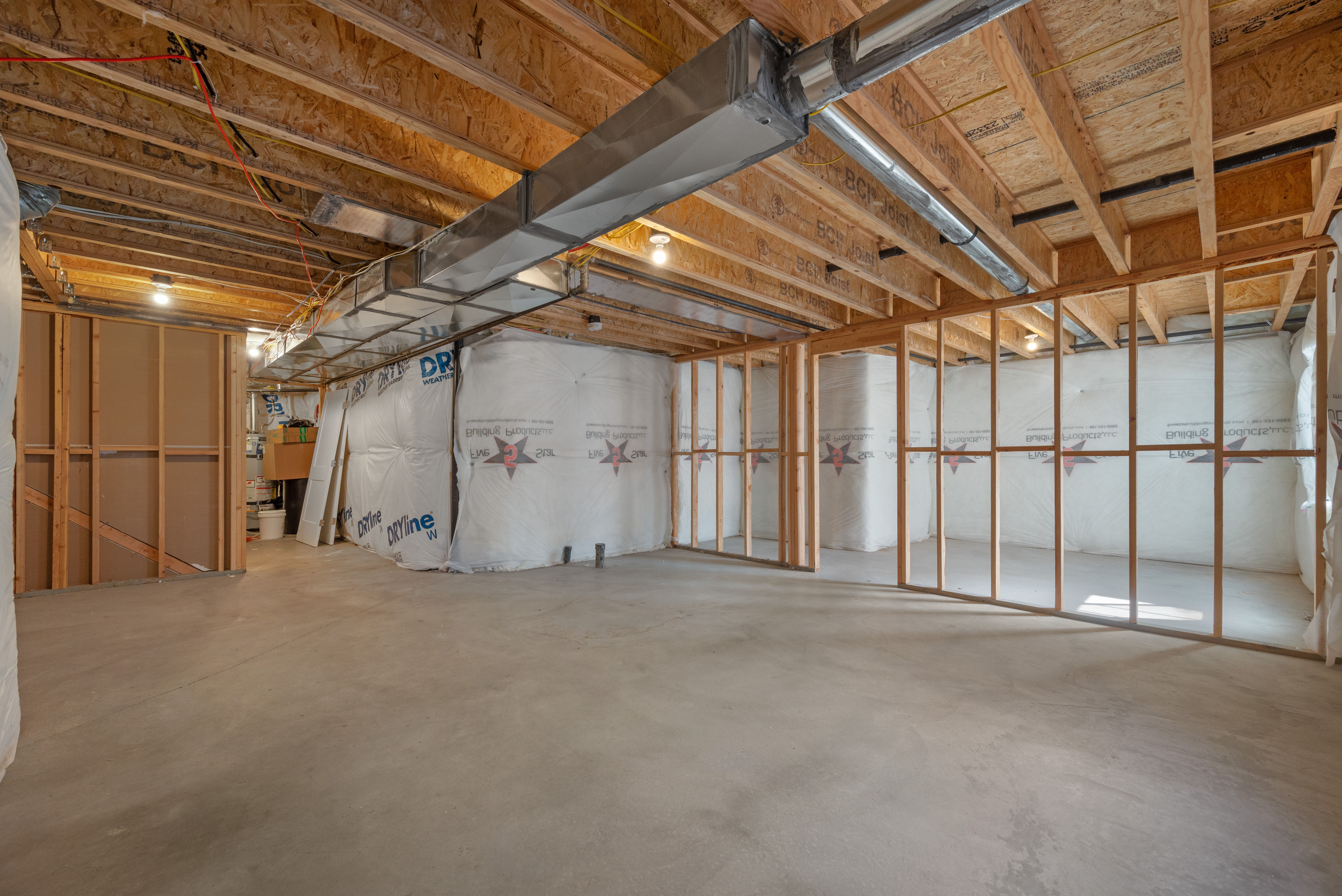Unfinished basement with concrete flooring and exposed ceiling joists