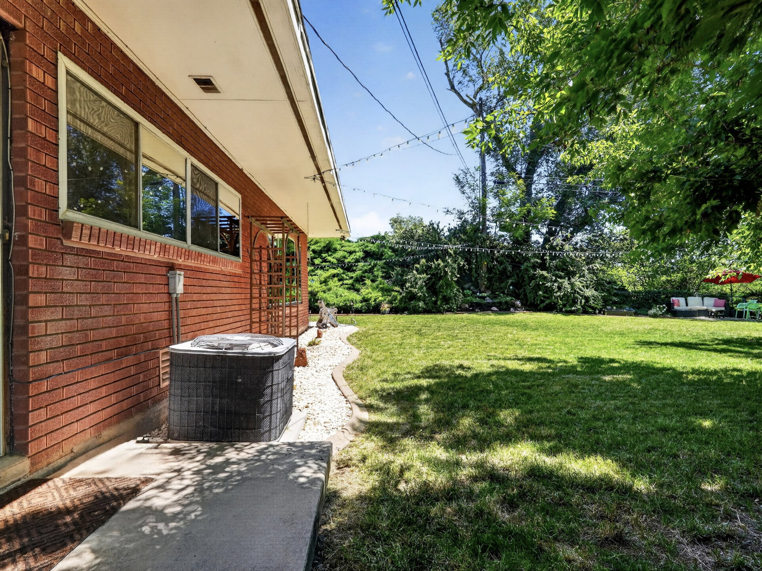 Secluded yard with mature trees and hedges providing privacy.