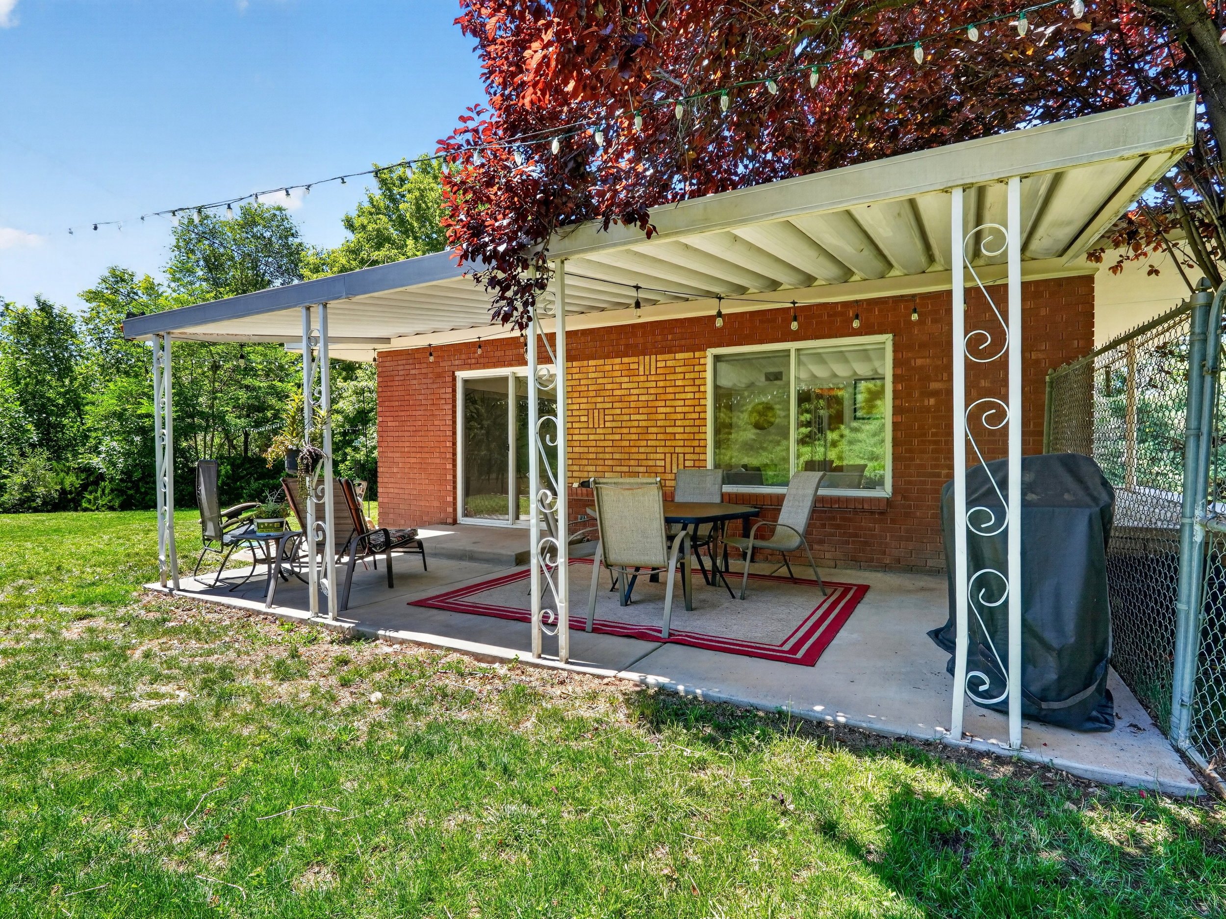 covered patio with sliding glass door. and bistro lights