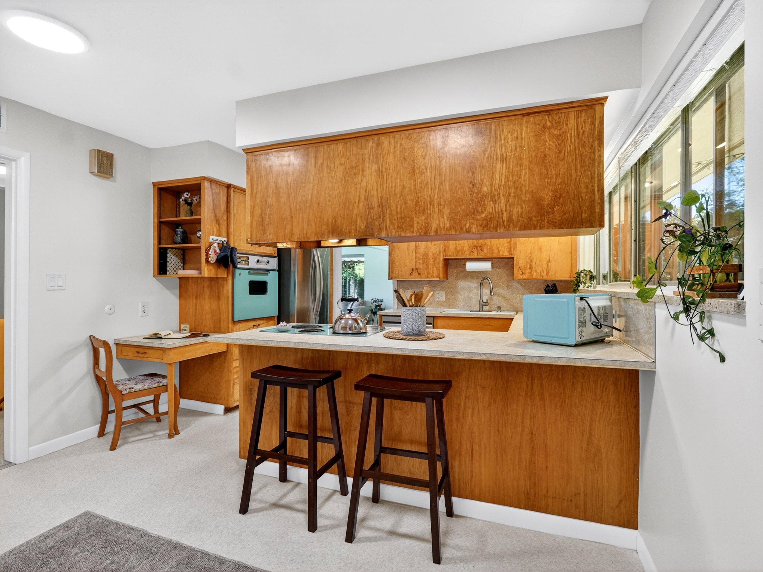 Open kitchen with breakfast bar and robin's egg blue retro wall oven and cooktop