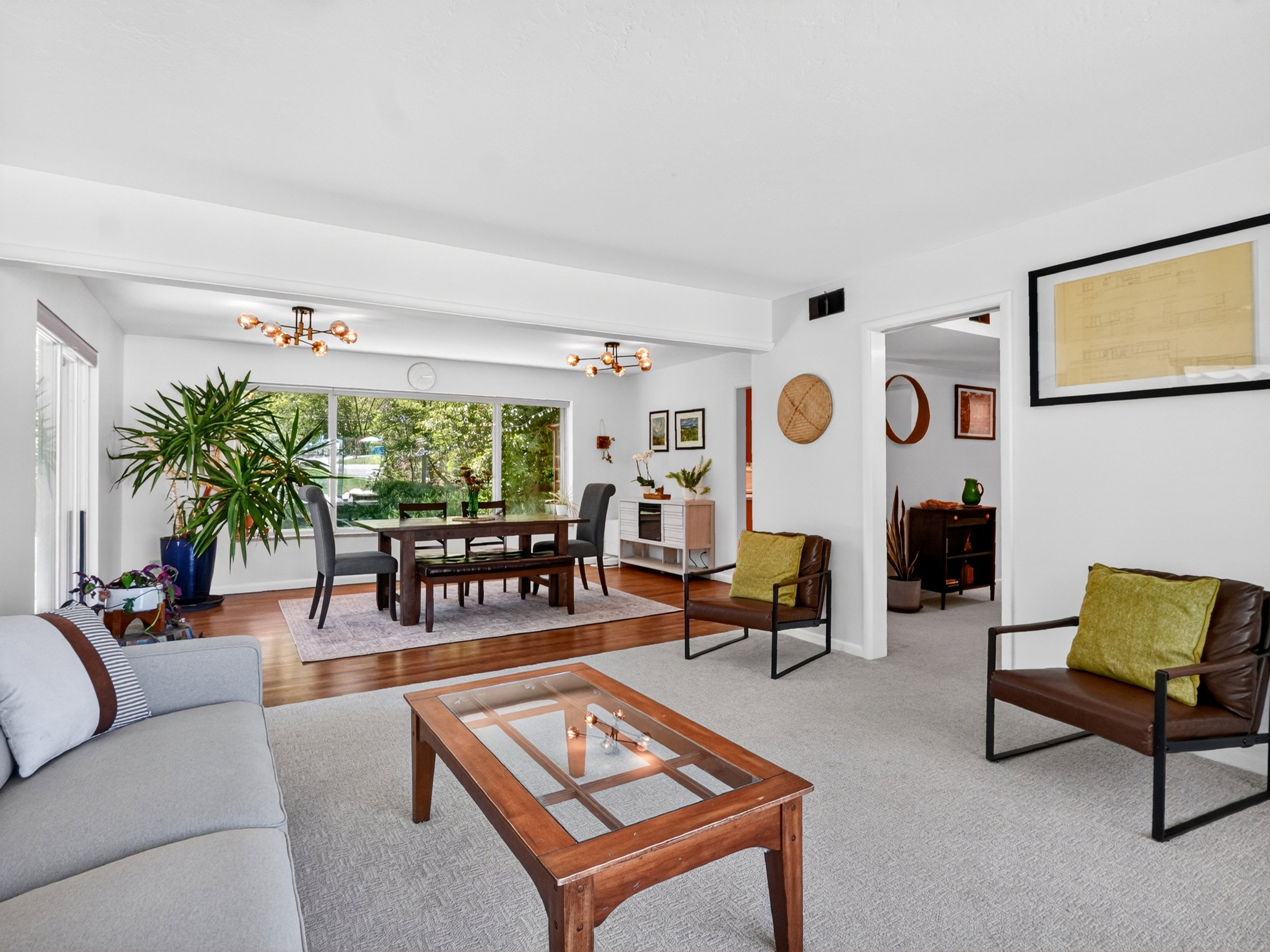Bright open-concept living space featuring expansive windows and easy flow into dining space