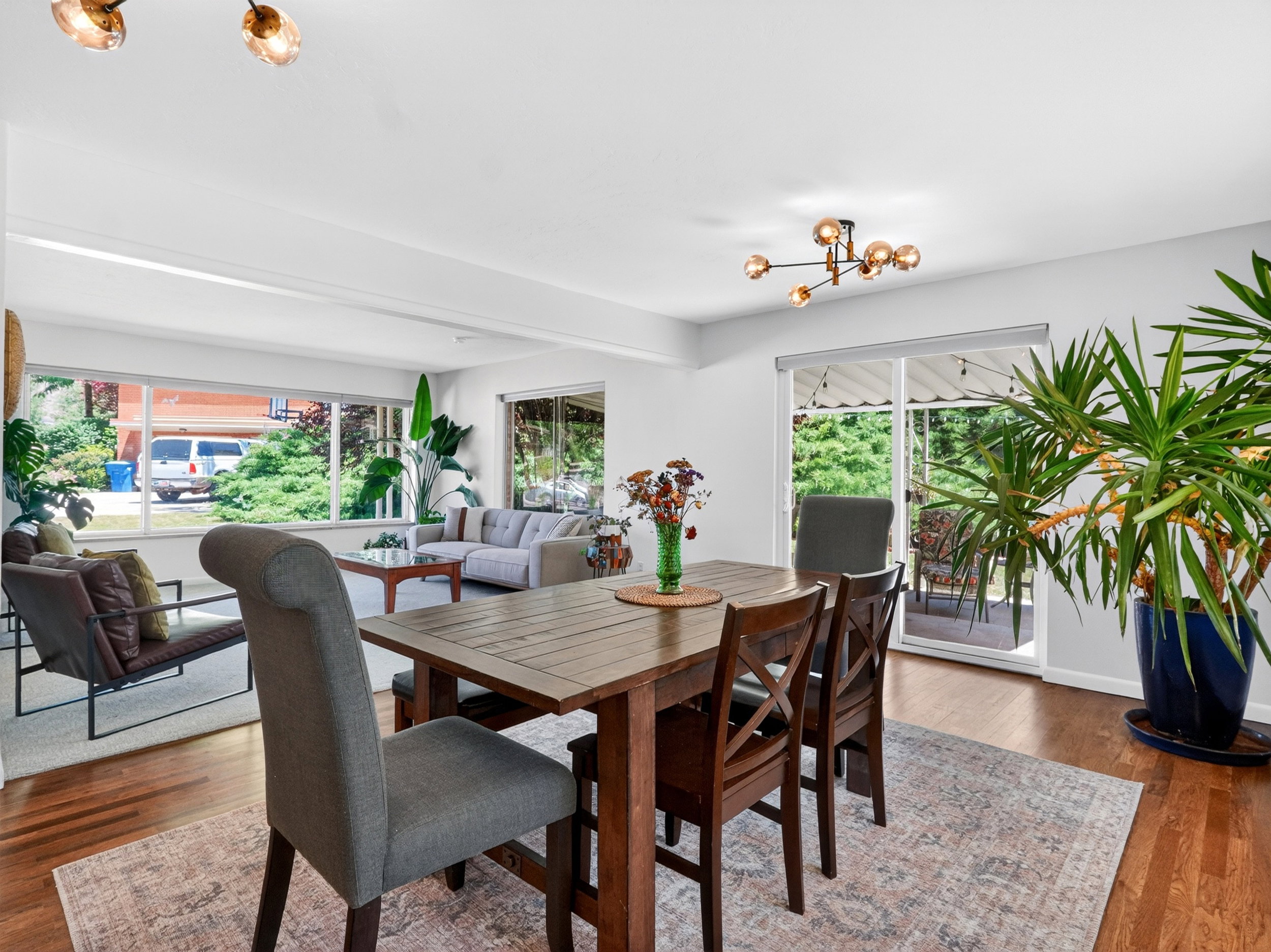 Bright open-concept dining space featuring expansive windows and sliding glass door access to patio.