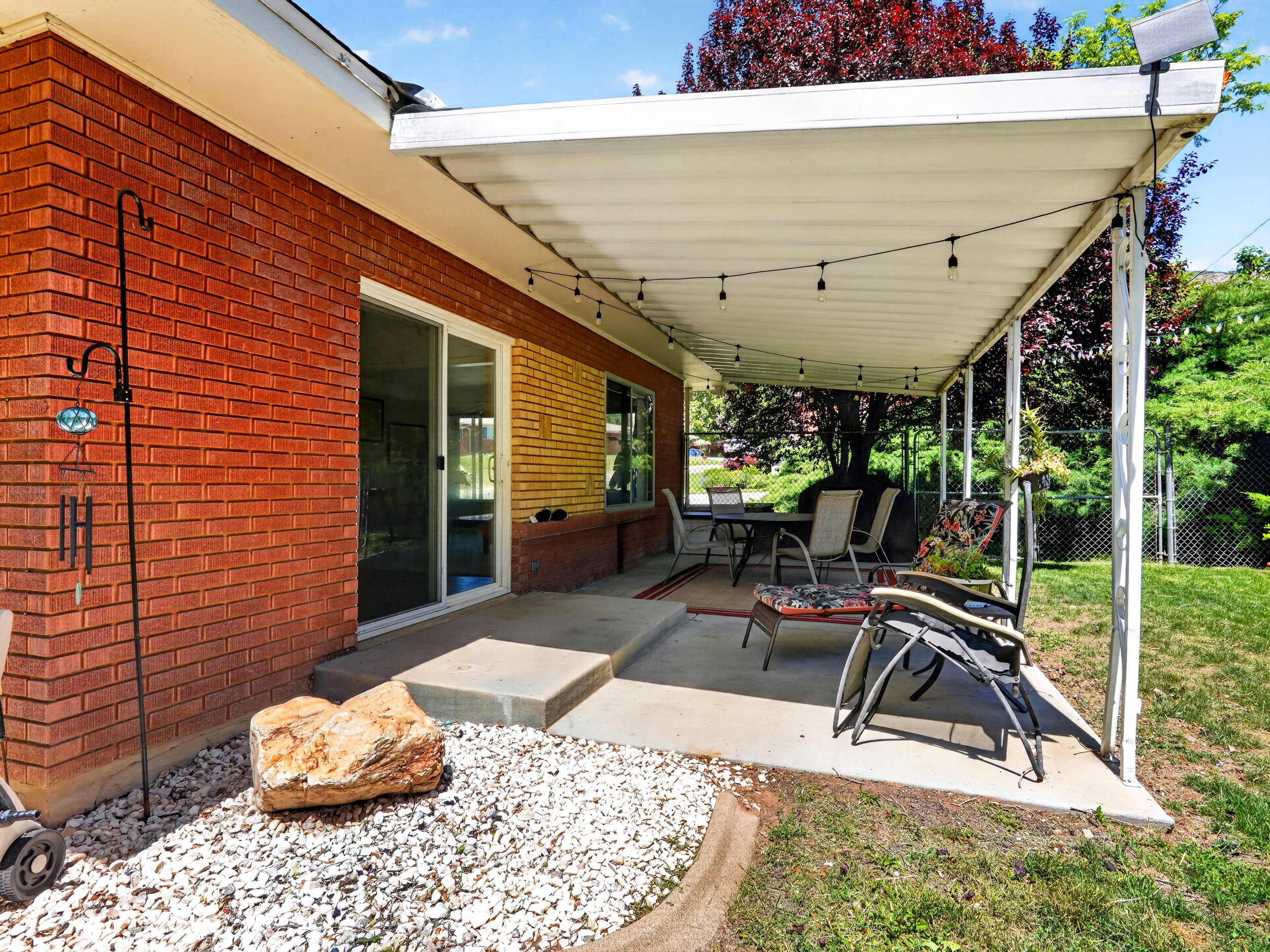 covered patio with sliding glass door. and bistro lights