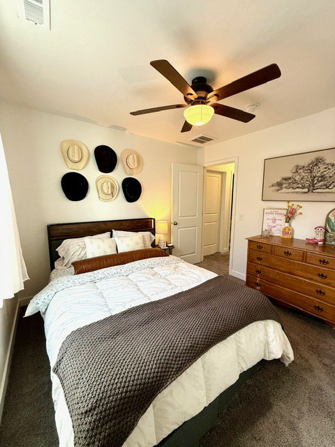 Bedroom featuring wall-to-wall carpeting and a dark wood headboard