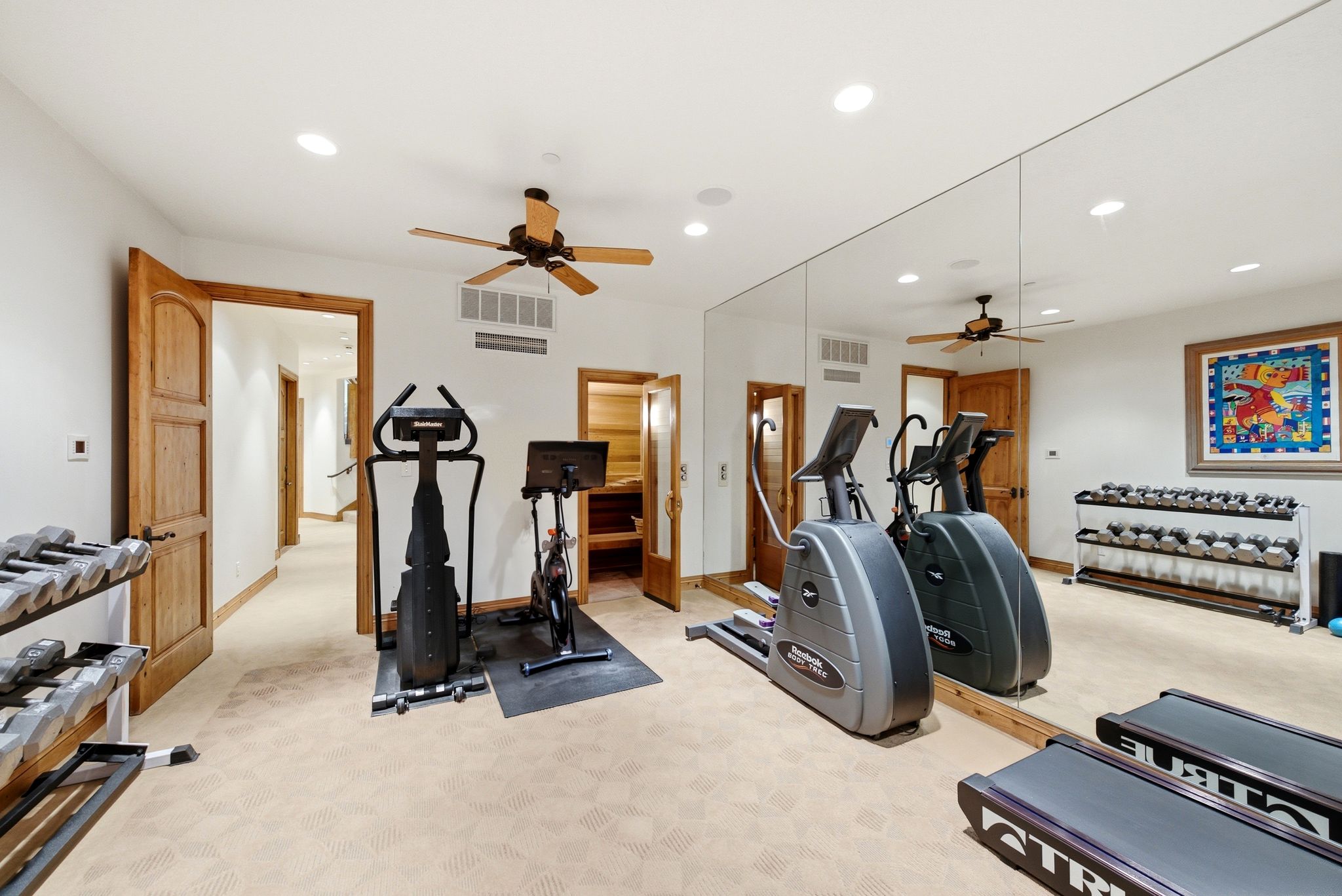 Dedicated fitness area featuring patterned carpet flooring, a full-wall mirror, and recessed lighting