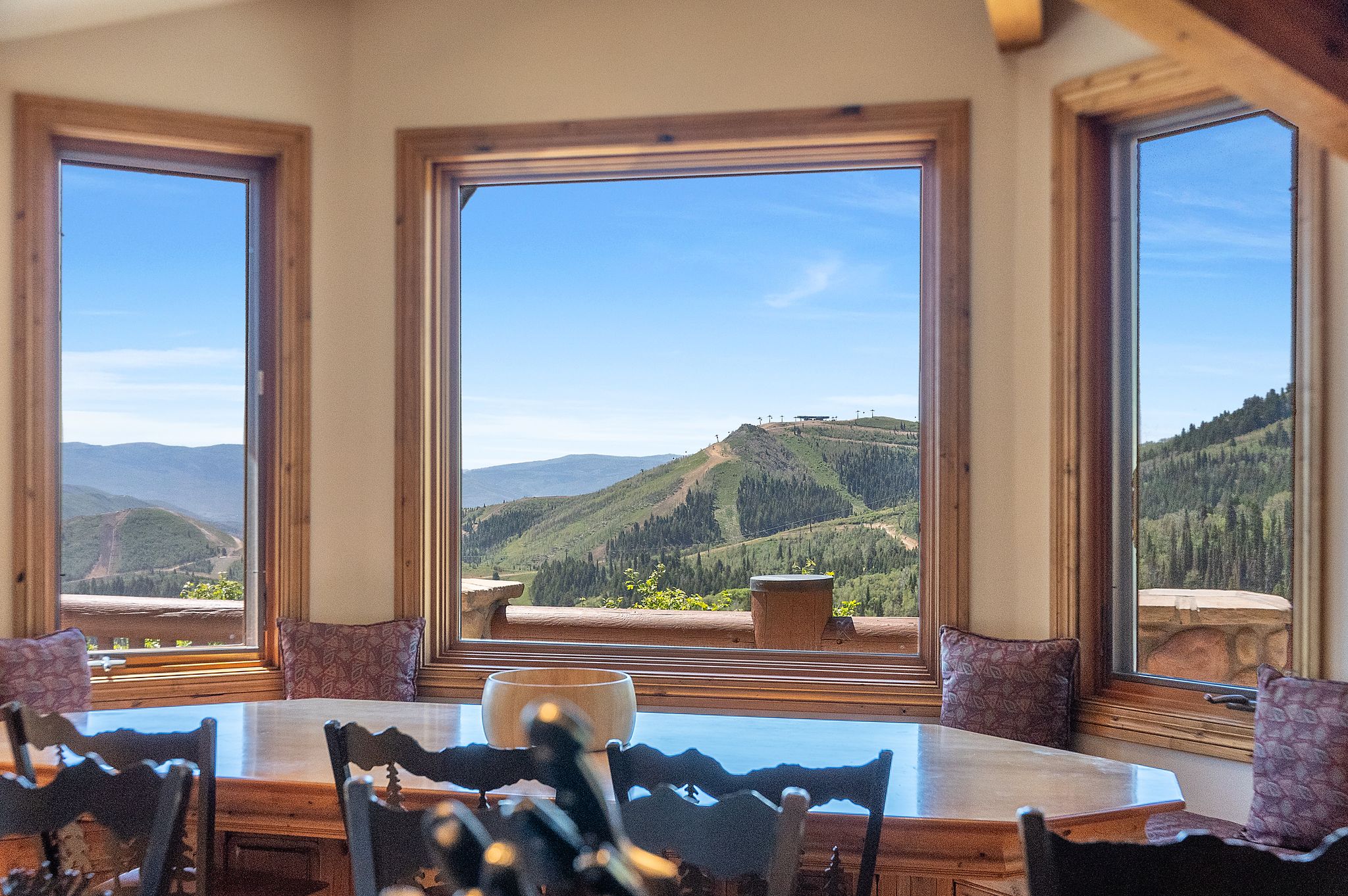 Expansive windows with wood trim frame mountain and ski slope scenery