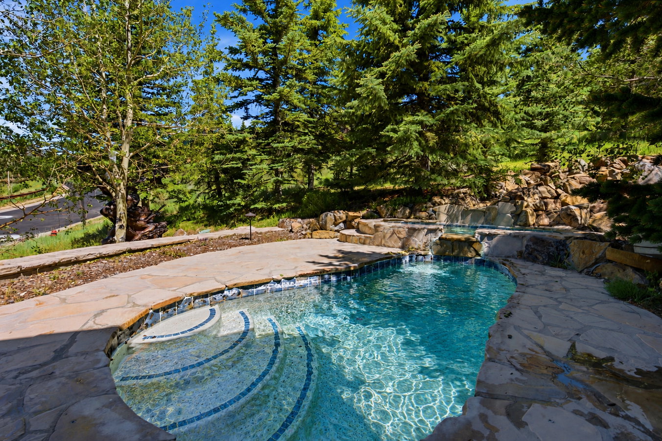 Swimming pool with flagstone surround and integrated waterfall feature