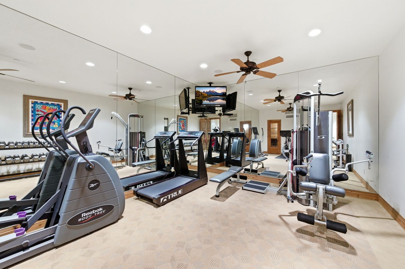 Dedicated fitness area featuring extensive mirrored walls, recessed lighting, and ceiling fans