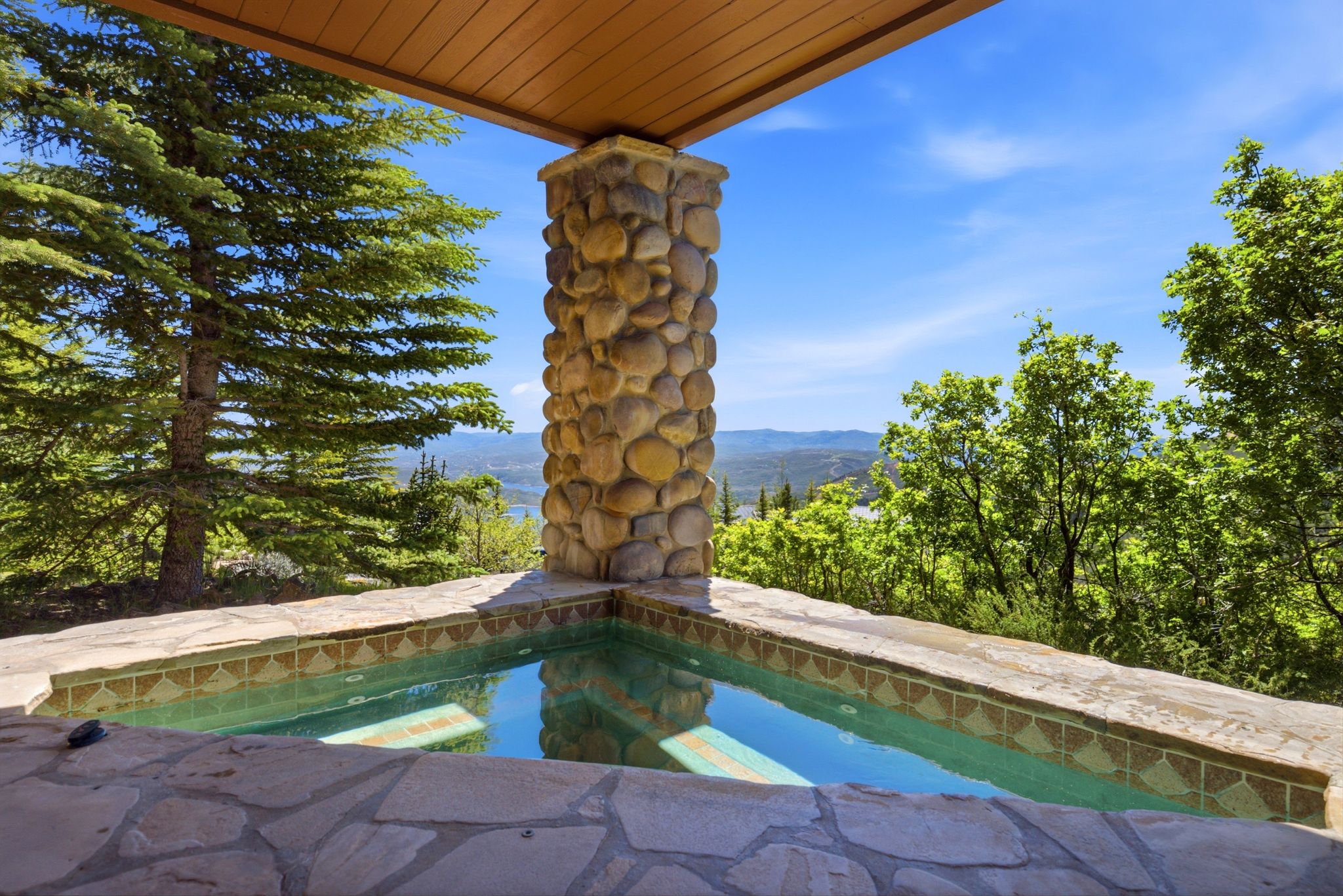 Outdoor spa with flagstone surround and decorative tile inlay