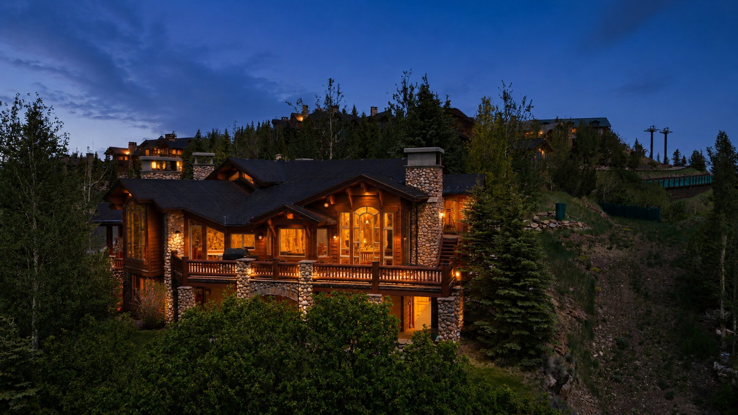 Multi-level property featuring wood siding and stone accents
