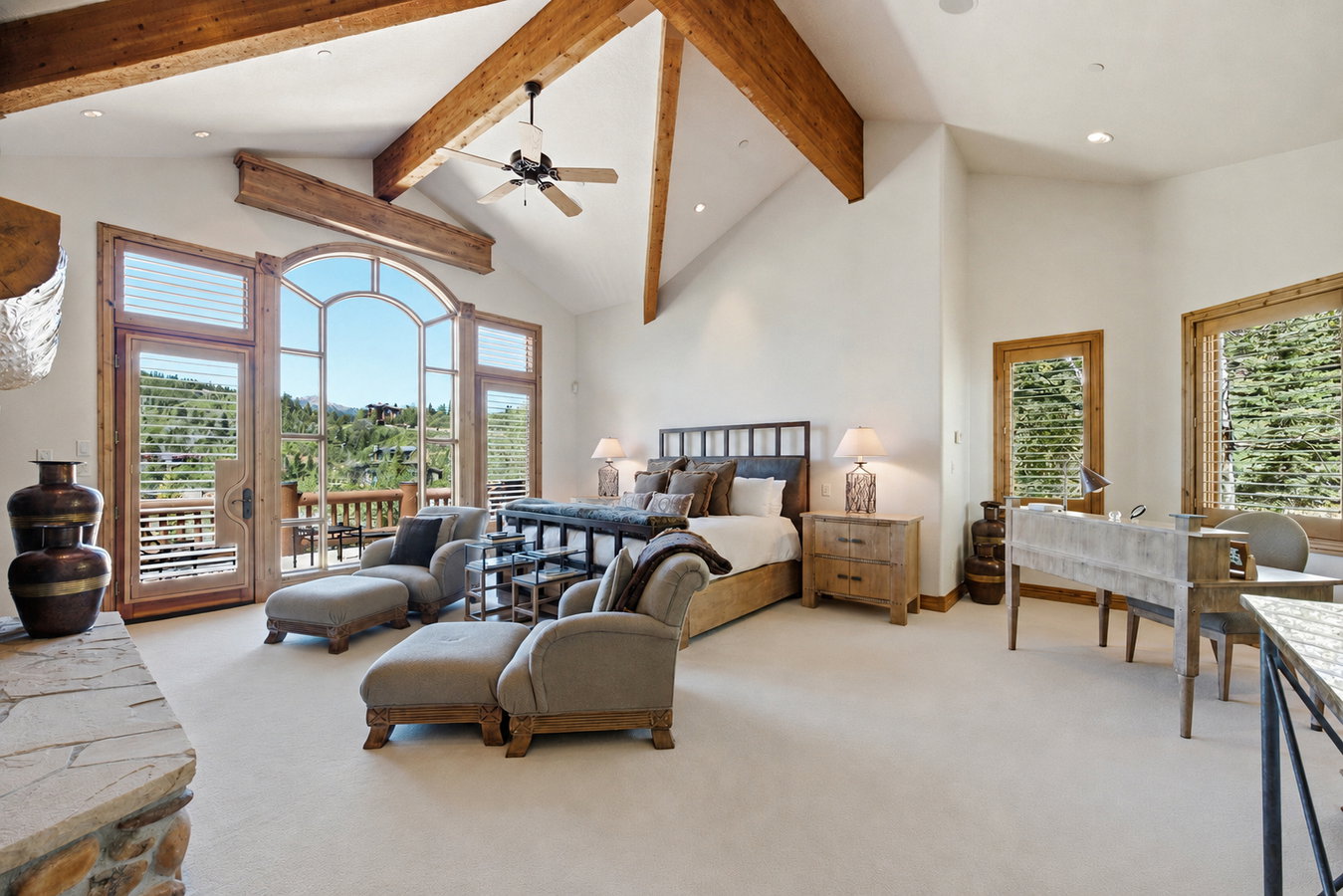 Vaulted ceiling with exposed wood beams and a ceiling fan