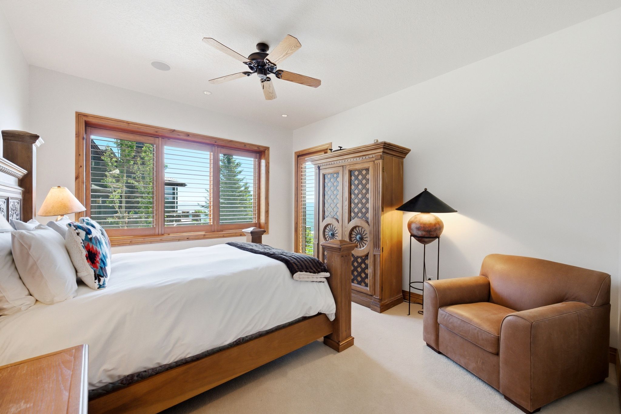 Spacious room with a large window featuring natural wood trim and plantation shutters, recessed lighting, and a ceiling fan
