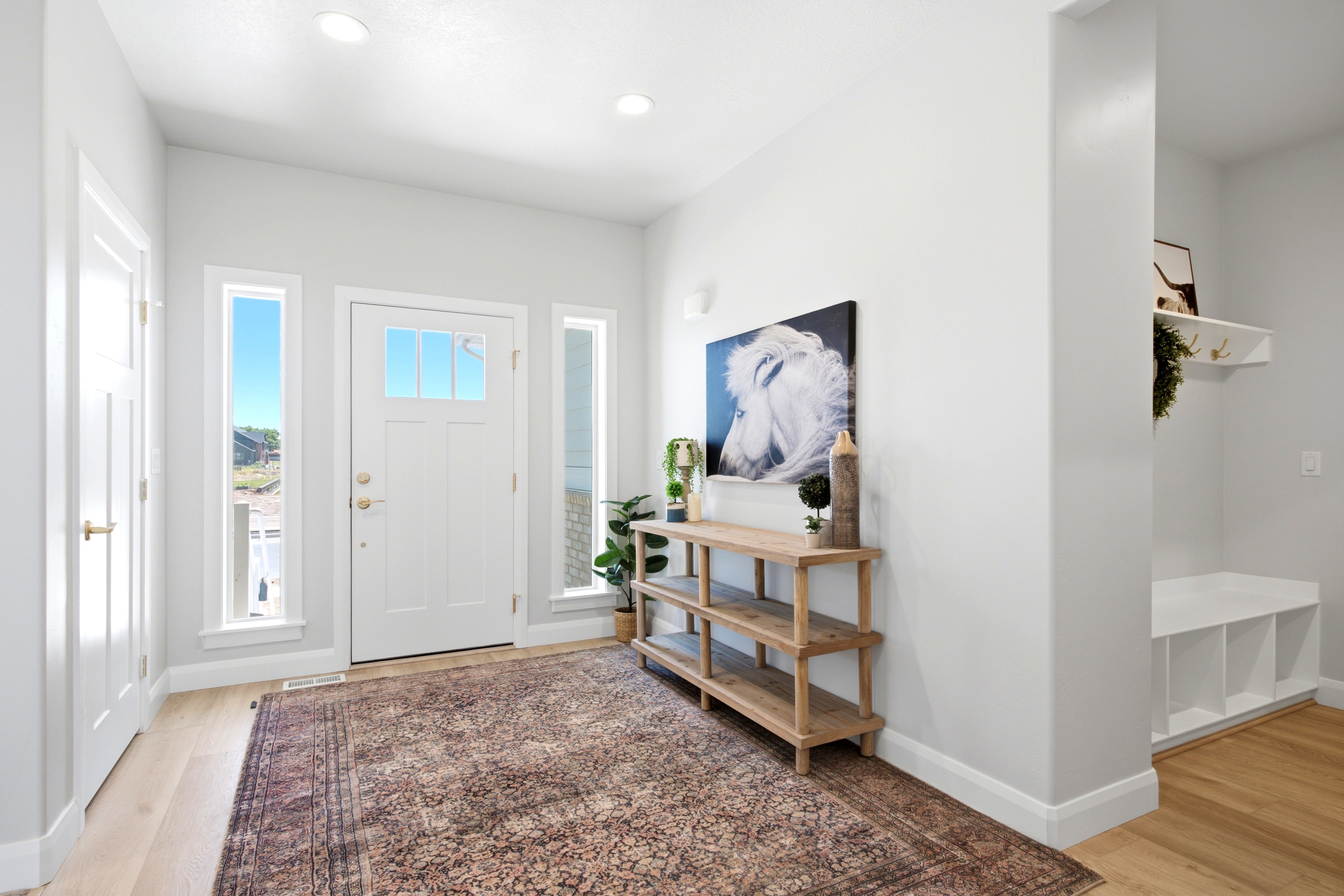 Entry foyer featuring wood-finish flooring, recessed lighting, and a white paneled door with glass inserts