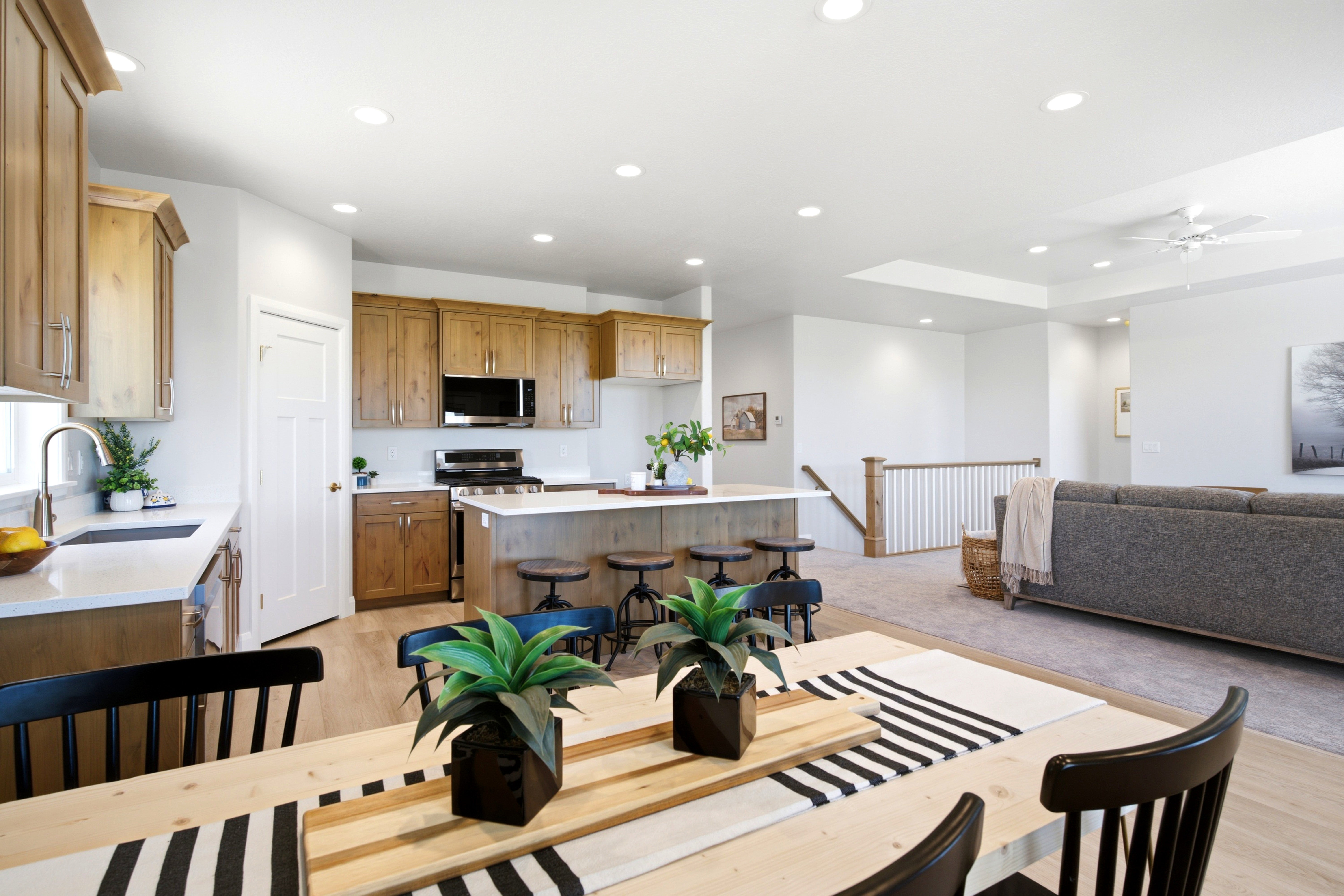 Open-concept living space with light wood-finish flooring in the dining area and kitchen
