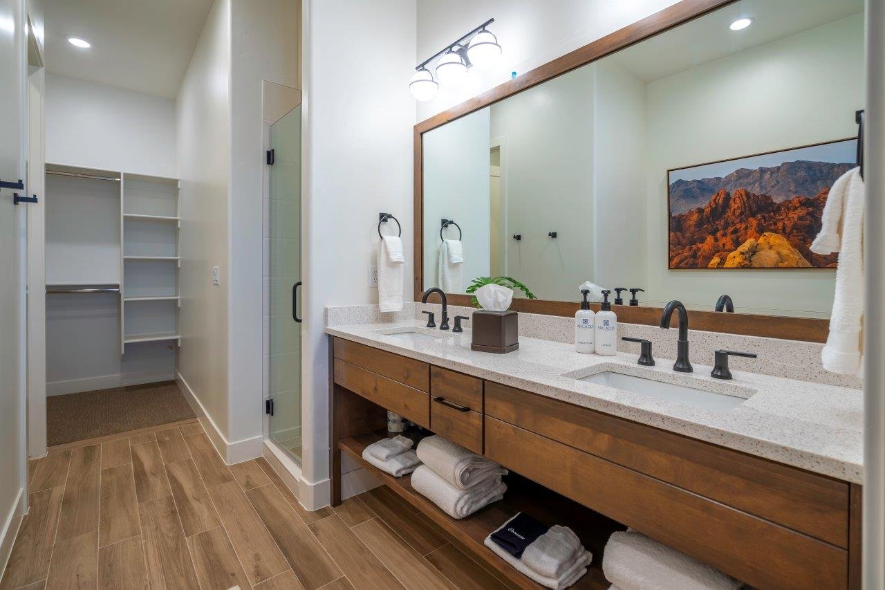 Double vanity with a wood-finish cabinet, light-colored countertop, and dual sinks featuring matte black fixtures