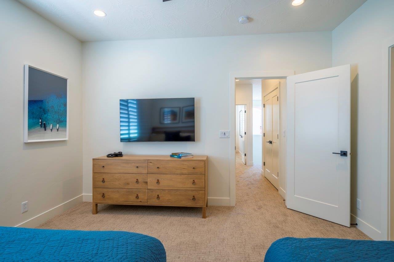 Carpeted room featuring recessed lighting, white trim, and a solid core interior door with a matte black lever handle