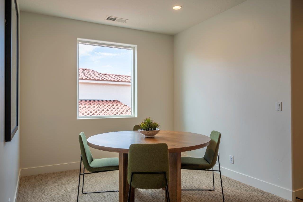 Bright interior space featuring a single window, recessed ceiling lighting, and light-colored carpeting