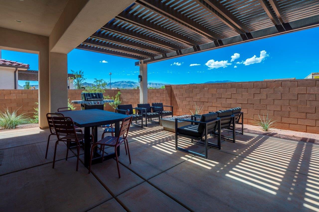 Covered patio featuring a slatted pergola roof and concrete slab flooring