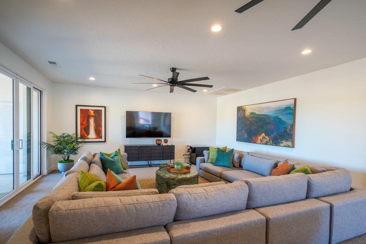 Spacious living area featuring light-toned walls, recessed lighting, and a contemporary ceiling fan