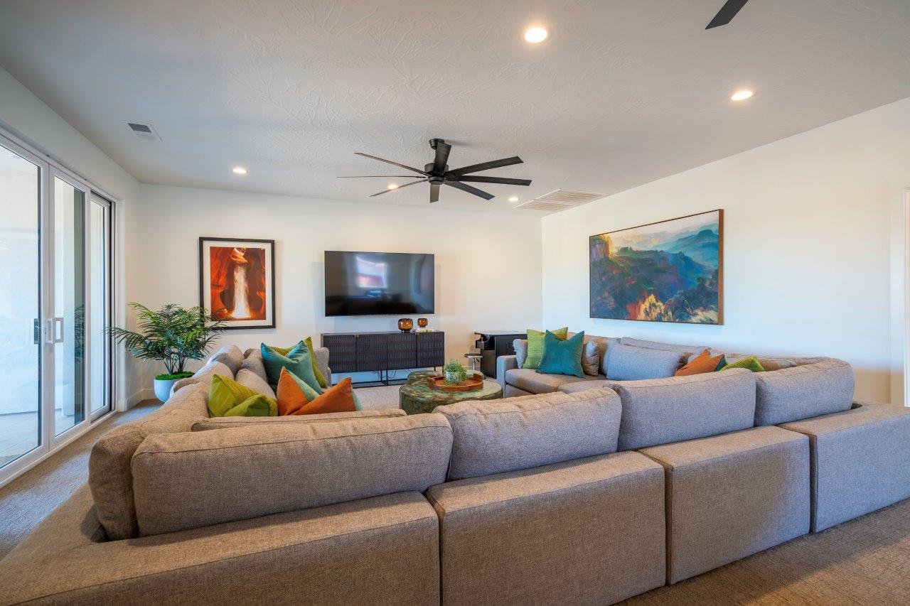 Spacious living area featuring light-colored carpet, white walls, and recessed lighting