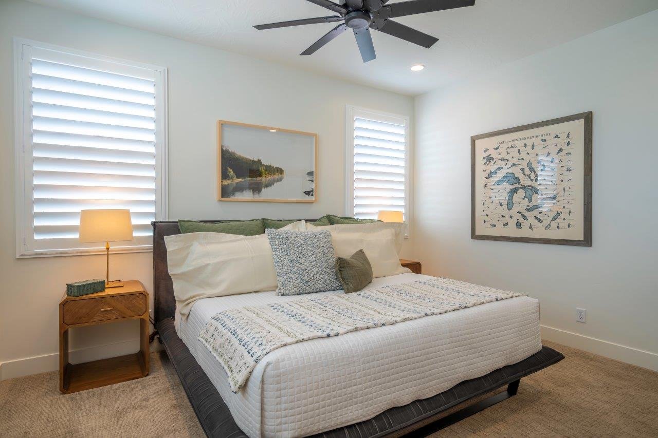 Bedroom featuring a ceiling fan with integrated lighting, recessed lighting, and two windows with white plantation shutters