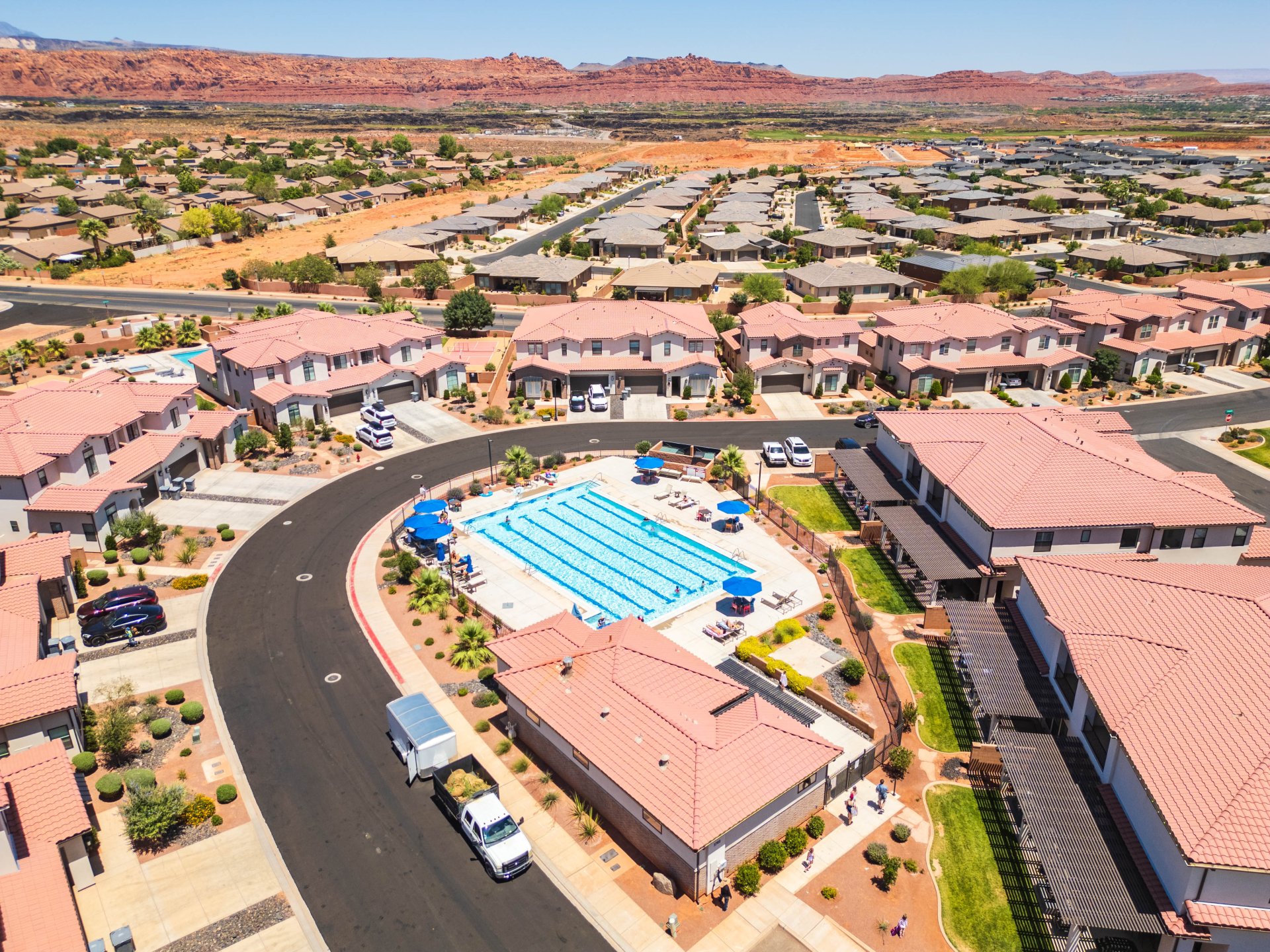 Community pool surrounded by desert landscaping and residential properties