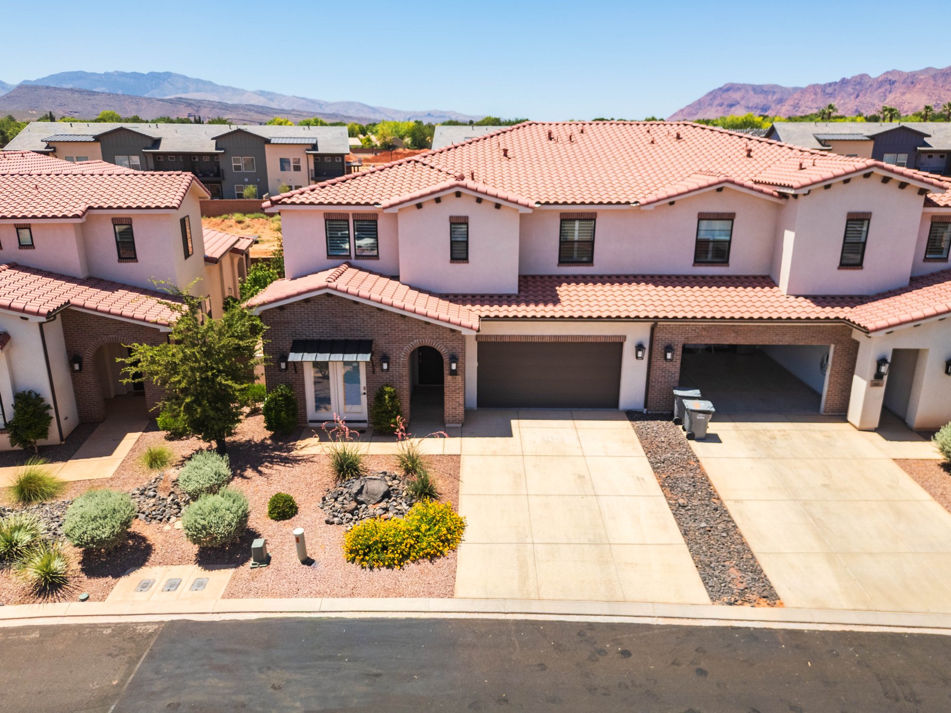 Spanish Colonial style exterior featuring a red tile roof, stucco finish, and brick accents