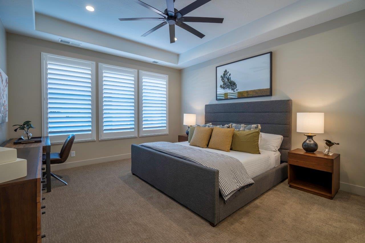 Spacious bedroom featuring a tray ceiling with recessed lighting, a ceiling fan, and carpeted flooring