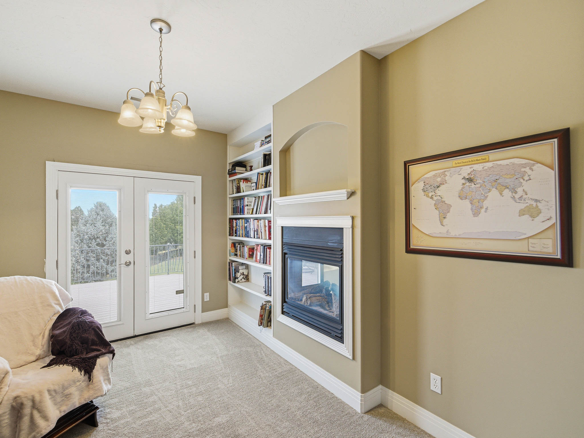 Room featuring built-in shelving, a fireplace with mantel, and white French doors