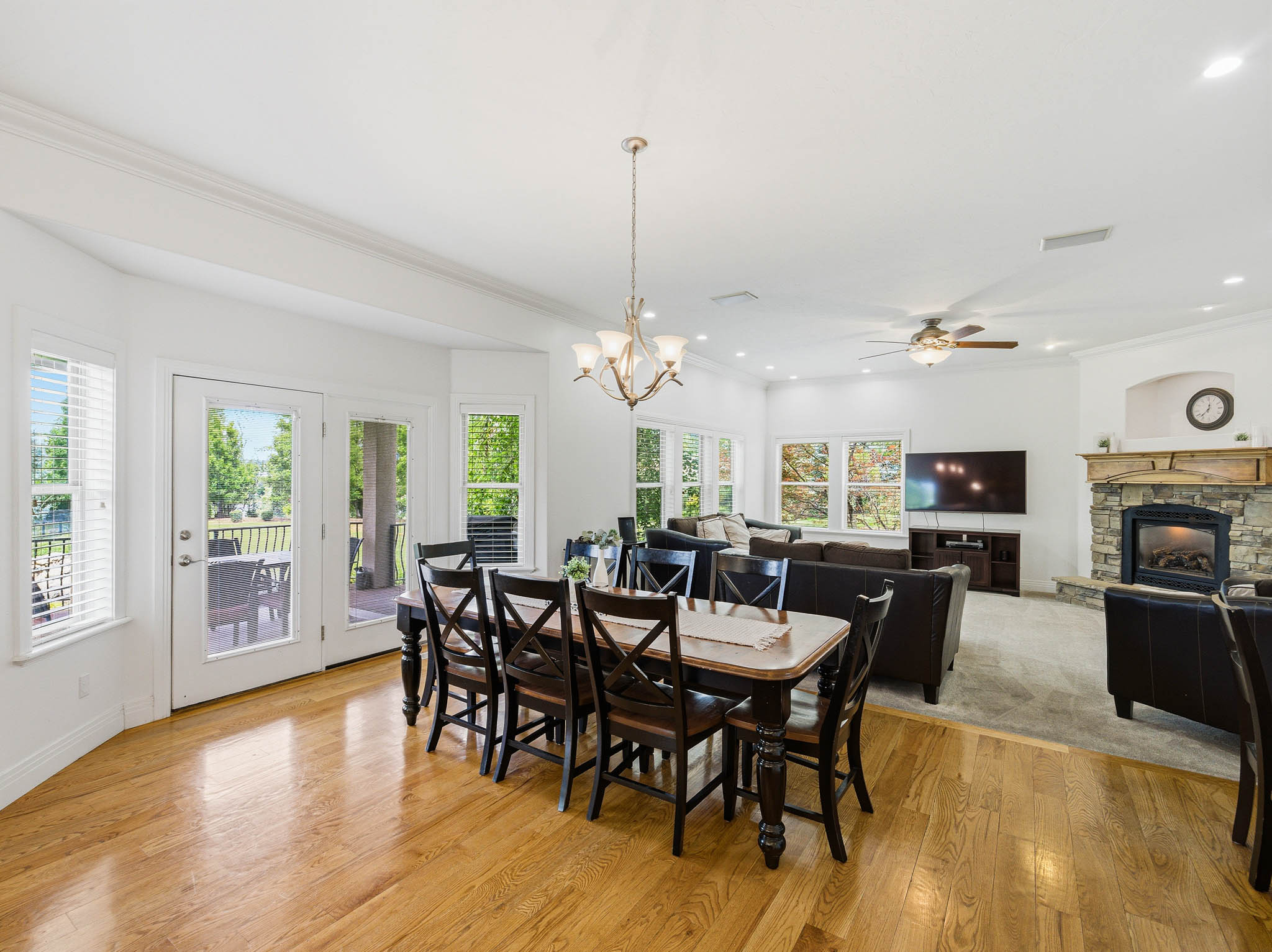 Spacious dining area featuring wood-finish flooring, a contemporary chandelier, and French doors leading to an exterior deck