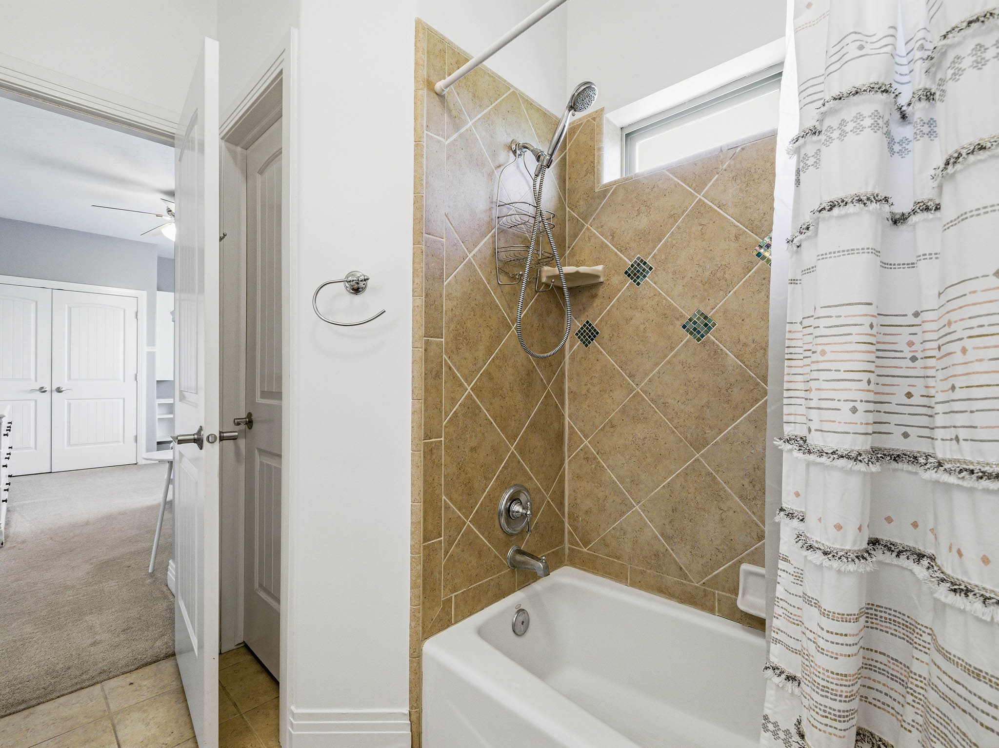 Bathtub with tile surround featuring decorative accents