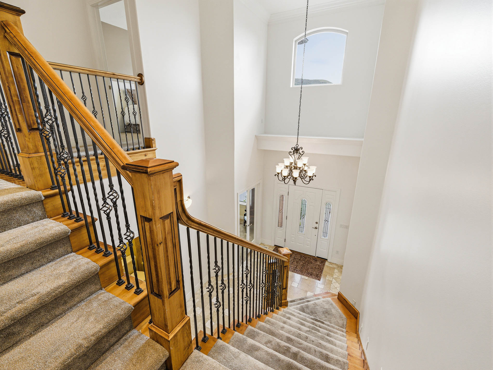 Grand foyer with a double-door entry and transom window, featuring a two-story ceiling