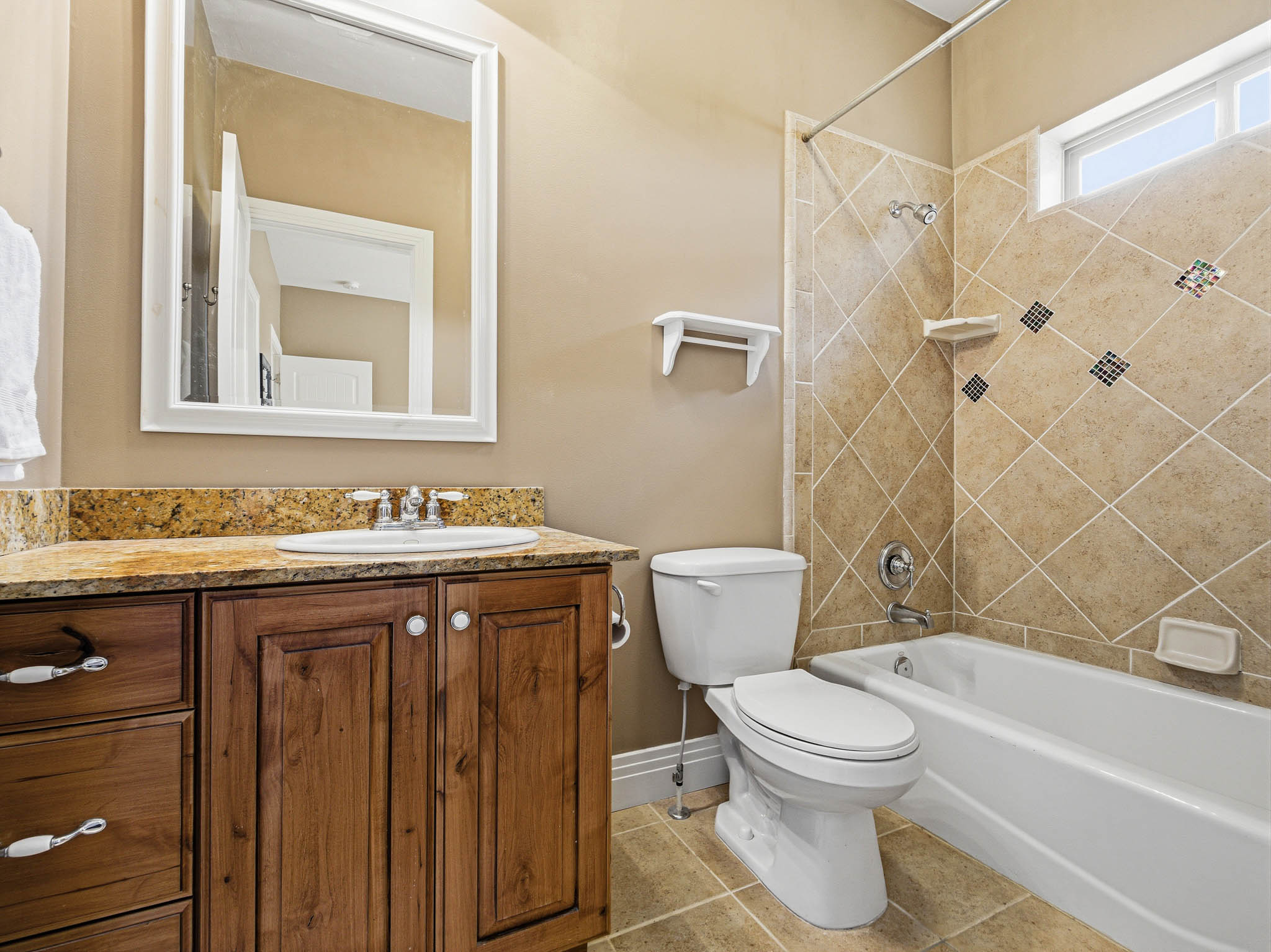 Bathroom featuring a wood vanity with a granite countertop and integrated sink
