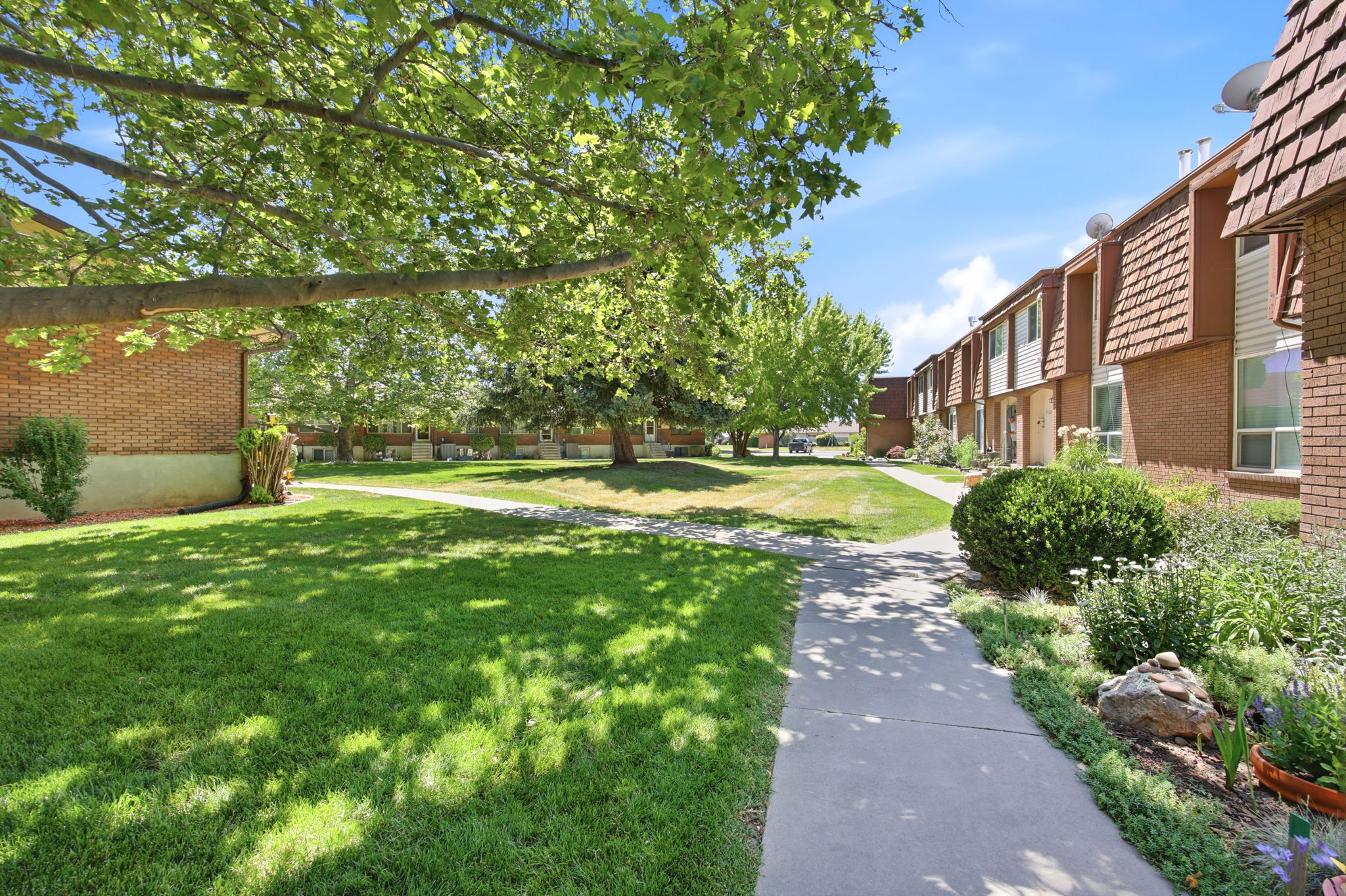 Landscaped grounds featuring mature trees and green lawns