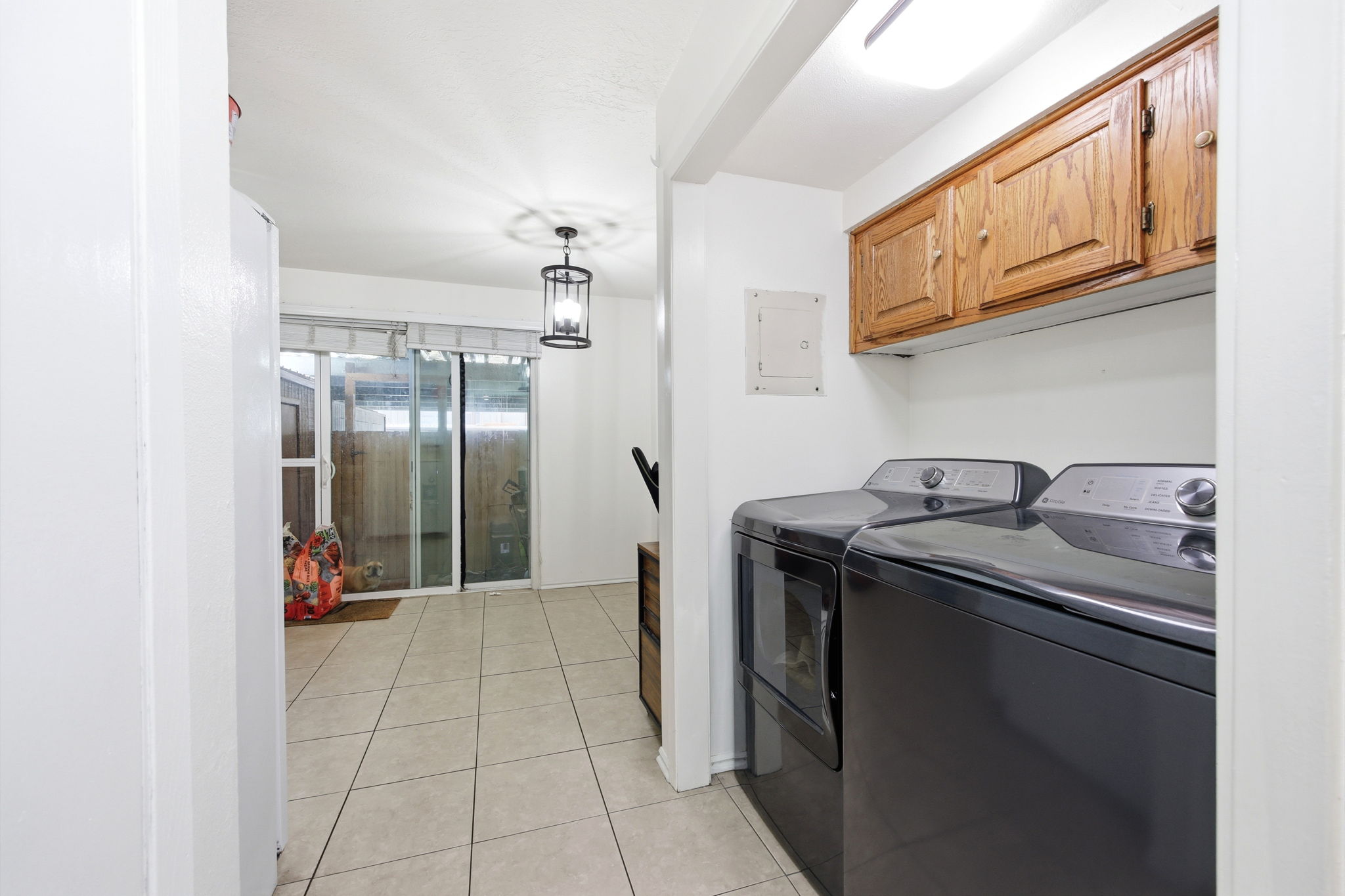 Laundry area featuring wood-finish cabinetry and built-in overhead lighting