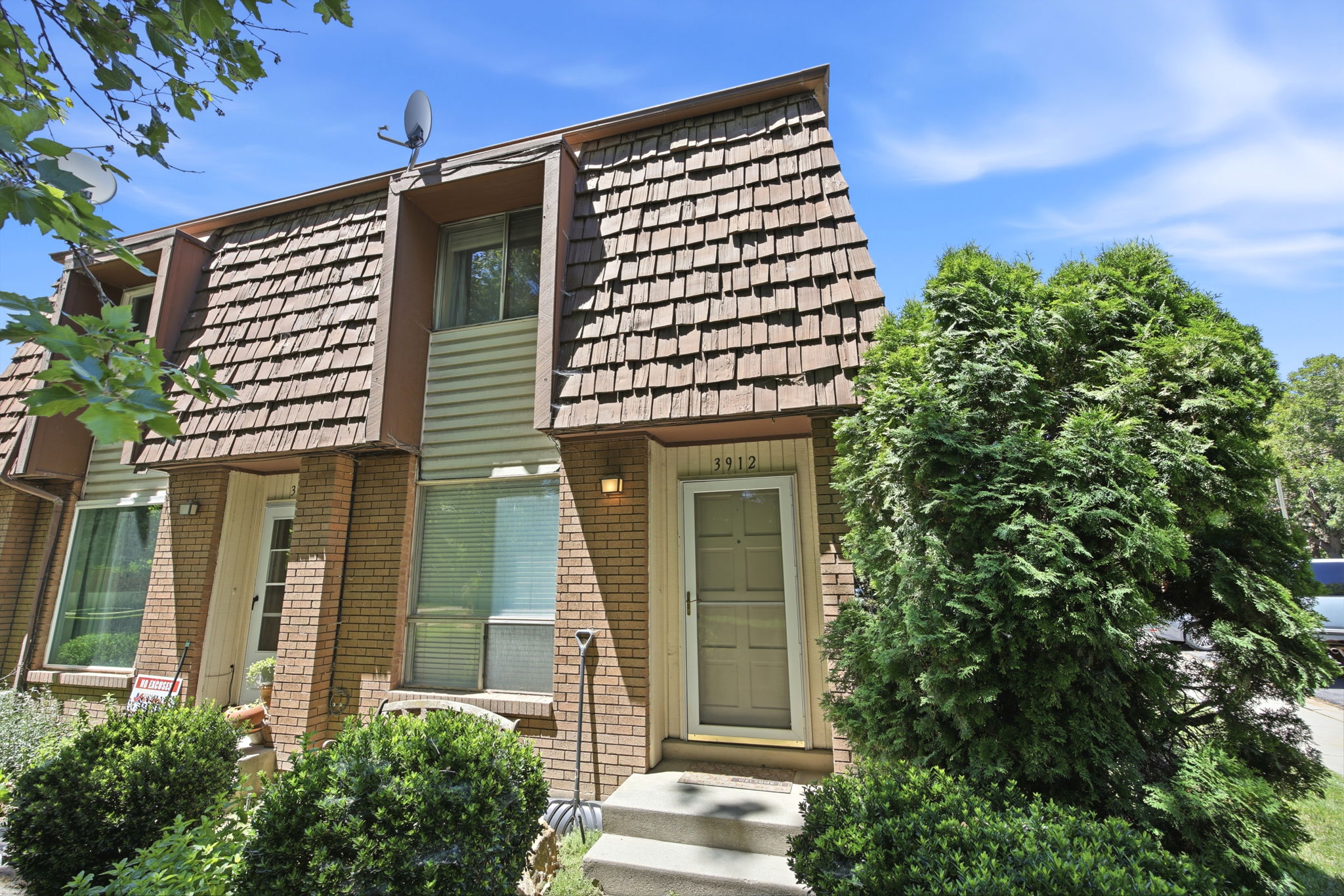 Brick exterior with a prominent A-frame roofline featuring wood shake shingles