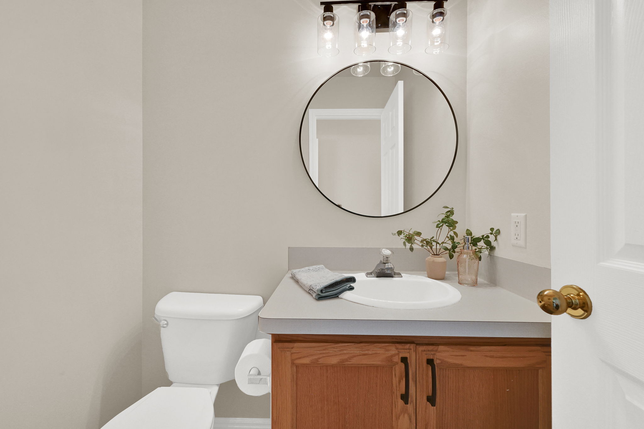 Bathroom featuring a vanity with a light-toned countertop, an integrated sink, and wood-finish cabinetry with dark hardware