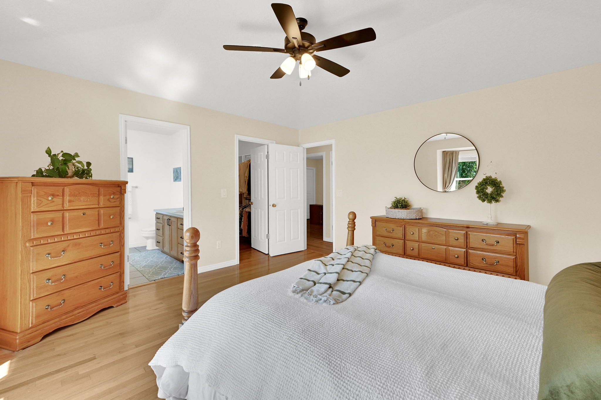 Room featuring neutral wall tones, wood-finish flooring, and a ceiling fan with integrated lighting