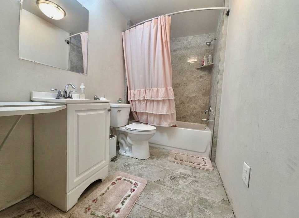 Bathroom featuring a white vanity with a single sink, an integrated countertop, and a chrome faucet